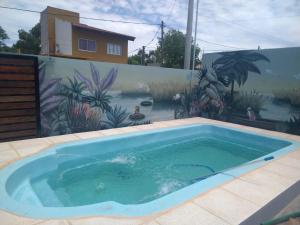 a swimming pool in front of a wall with a painting at CABAÑAS CHASCOMUS 2024 in Chascomús