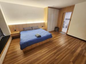 a bedroom with a bed and a wooden floor at Kota Kinabalu family Home in Kota Kinabalu