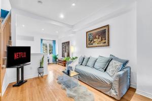 sala de estar con sofá y TV en Townhome by Subway and Downtown Toronto in Greektown, en Toronto