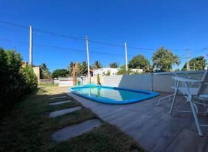 a swimming pool in a yard with a table at Bela casa condominio beira mar praia dos carneiros in Tamandaré