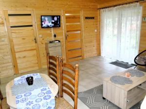 a kitchen with a table and a television in a room at House by the lake in Wiselka in Wisełka