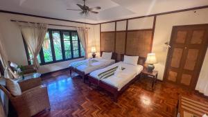 a bedroom with two beds and a ceiling fan at Fern Resort Mae Hong Son in Mae Hong Son