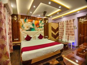 a bedroom with a bed with a painting on the wall at THE PELICAN BEACH RESORT in Mandarmoni