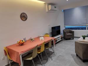 comedor con mesa, sillas y TV en PERSEUS 3 BEDROOM Apartment 102 en Lárnaca