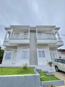 Biały dom z samochodem zaparkowanym przed nim w obiekcie Villa Shafa Marwa w mieście Bukittinggi