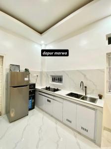 Kuchnia wyposażona jest w blaty z białego marmuru i lodówkę. w obiekcie Villa Shafa Marwa w mieście Bukittinggi