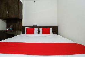 Bett mit roten Kissen in einem Zimmer in der Unterkunft OYO Hotel Rk Inn in Ludhiana