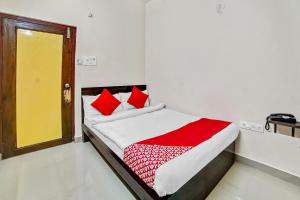 1 dormitorio con 1 cama con almohadas rojas y blancas en Collection O 45443 Hotel Suvidha, en Bilāspur