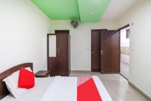 Un dormitorio con una cama con una almohada roja. en OYO Flagship 62748 Hotel Zeenat, en Jammu