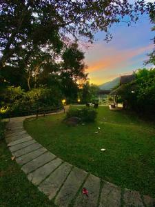 a path in a park with a sunset in the background at Fern Resort Mae Hong Son in Mae Hong Son