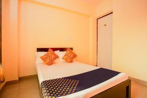 a bedroom with a bed with orange and blue pillows at SPOT ON Pawan Villa in Gorhe +25 photos