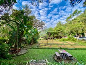 a picnic table and benches in a yard at Fern Resort Mae Hong Son in Mae Hong Son