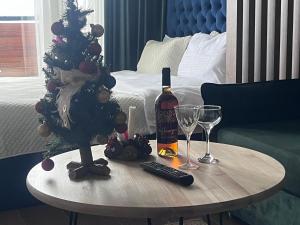 a table with a bottle of wine and a christmas tree at Twins apartment delux 2, new gudauri in Gudauri