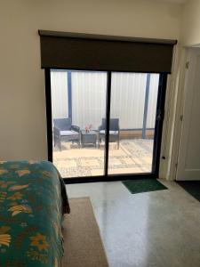 a room with a large sliding glass door to a patio at Erowal Bay Guesthouse Jervis Bay in Erowal Bay