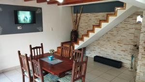 une salle à manger avec une table, des chaises et un escalier dans l'établissement Esquel house, à Esquel