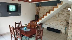 a dining room with a table and chairs and a staircase at Esquel house in Esquel