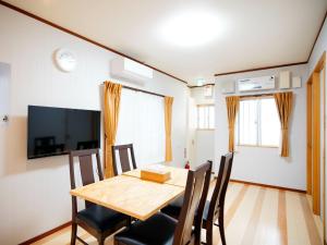 uma sala de jantar com uma mesa de madeira e cadeiras em Mcity in Maejima - Vacation STAY 54956v em Naha
