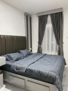 sypialnia z łóżkiem z niebieską pościelą i oknem w obiekcie Villa Shafa Marwa w mieście Bukittinggi