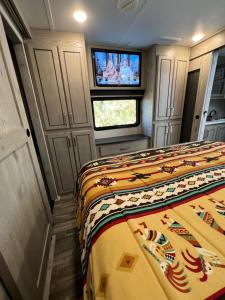 een kleine kamer met een bed en een televisie bij JMA Alpine Inn in Riverton