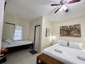 a bedroom with two beds and a ceiling fan at The Duyan House at Sinagtala Resort in Orani