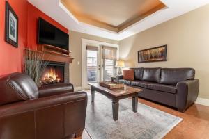 a living room with leather furniture and a fireplace at Solara Suite with Indoor Pool - Hot tub -Parking - GYM in Canmore