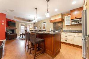 a kitchen with a island with bar stools at Solara Suite with Indoor Pool - Hot tub -Parking - GYM in Canmore
