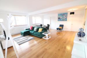 a living room with a green couch and a desk at Garland Lovely Apartment, St John's Wood in London