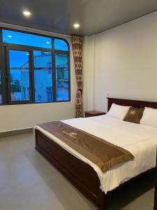 a bedroom with a bed and a large window at Homestay Bối Bối in Thôn Kim Long (1)