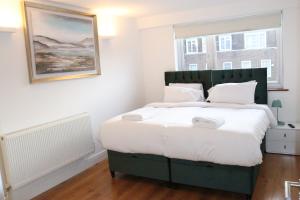 a bedroom with a large bed with a large window at Garland Lovely Apartment, St John's Wood in London