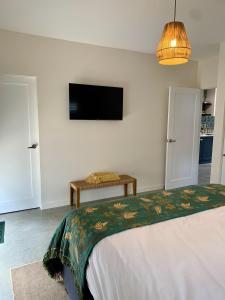 Schlafzimmer mit einem Bett und einem Flachbild-TV in der Unterkunft Erowal Bay Guesthouse Jervis Bay in Erowal Bay