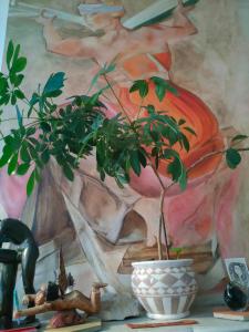 una pianta in un vaso accanto a un dipinto di Come&Sleep a Marsiglia