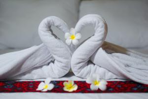 a couple of towels with flowers in them on a bed at Bello Bungalow in Batukliang +114 photos