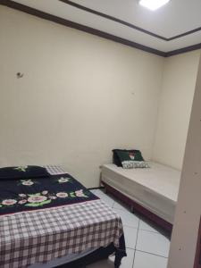 Duas camas num pequeno quarto com paredes brancas em House beach em Camocim