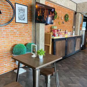 a restaurant with a wooden table in front of a brick wall at JB Place in Nakhon Pathom