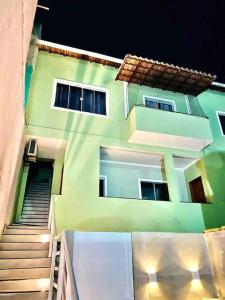 un edificio verde con escaleras que conducen a él en Arraial Temporada - Vá a Pé para a Praia, en Arraial do Cabo