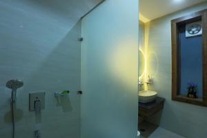 a bathroom with a shower with a sink and a toilet at Hriday Bhoomi - Luxury Cottages & Villa in Jim Corbett in Jhirna