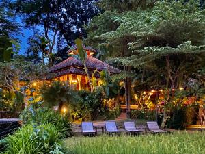 a group of chairs in front of a house at night at Fern Resort Mae Hong Son in Mae Hong Son