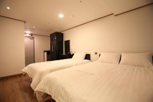 
a hotel room with two beds and a television at Myeongdong Mom House in Seoul
