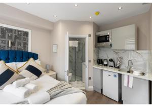 a bedroom with a king sized bed and a kitchen at Brand New Stunning and Cosy Studio - Very Central in London