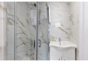 ein Bad mit einer Dusche und einem Waschbecken in der Unterkunft Brand New Stunning and Cosy Studio - Very Central in London
