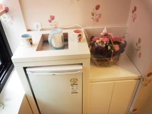 
a kitchen sink with a vase of flowers on top of it at Myeongdong Mom House in Seoul
