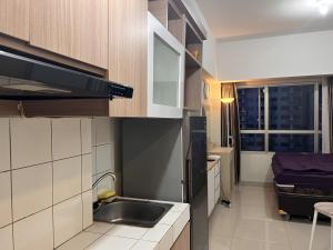een kleine keuken met een wastafel en een raam bij The Springlake Summarecon by Bonzela Property in Kandang Satu