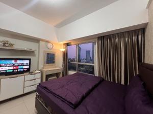 een slaapkamer met een bed en een groot raam bij The Springlake Summarecon by Bonzela Property in Kandang Satu