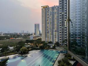 een uitzicht op een groot gebouw met een zwembad bij The Springlake Summarecon by Bonzela Property in Kandang Satu