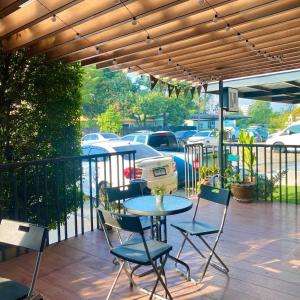 a patio with a table and chairs under a pergola at JB Place in Nakhon Pathom