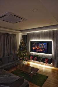 a living room with a christmas tree and a television at Kota Kinabalu family Home in Kota Kinabalu