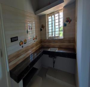 La salle de bains est pourvue d'un lavabo et d'une fenêtre. dans l'établissement Shalog Inn Homestay, à Thirumurugan Poondi