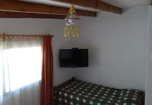 Habitación con cama, TV y ventana. en Las Cruces, en Las Cruces