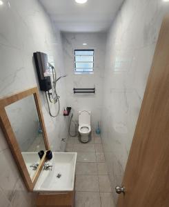 a bathroom with a sink and a toilet and a mirror at Kota Kinabalu family Home in Kota Kinabalu