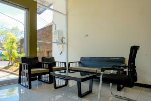 drie stoelen en een tafel in een kamer met een raam bij Rahayu Residence Syariah Kediri in Kediri